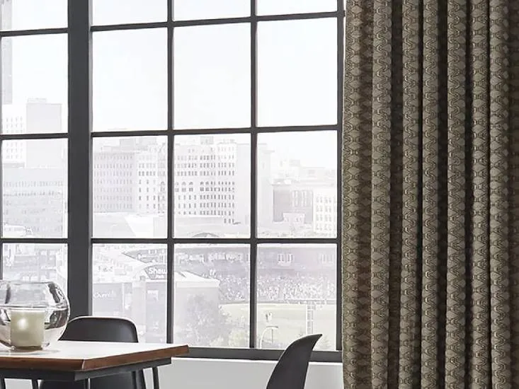 A stylish room with large windows and patterned curtains, showcasing interior design from Discount Best Blinds and Shutters in Santa Rosa.